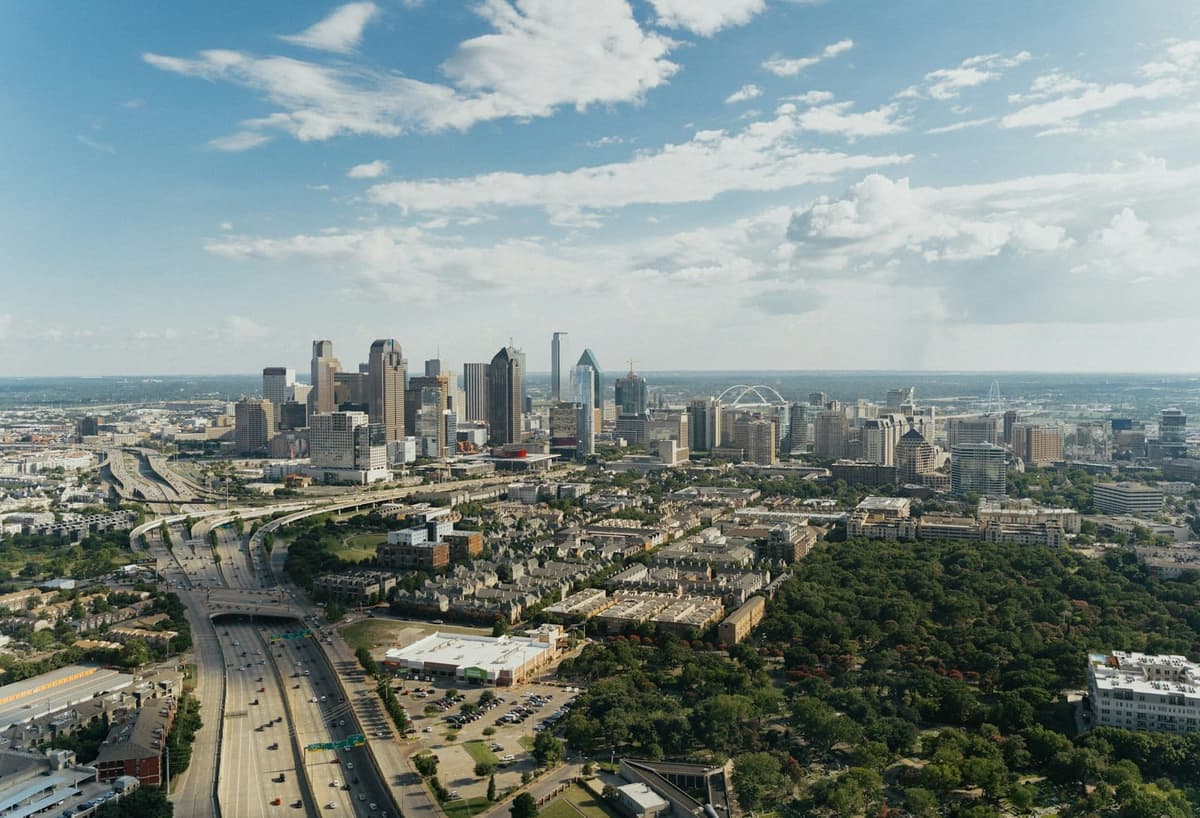 Aerial view of Dallas with green parkland and skyline beyond