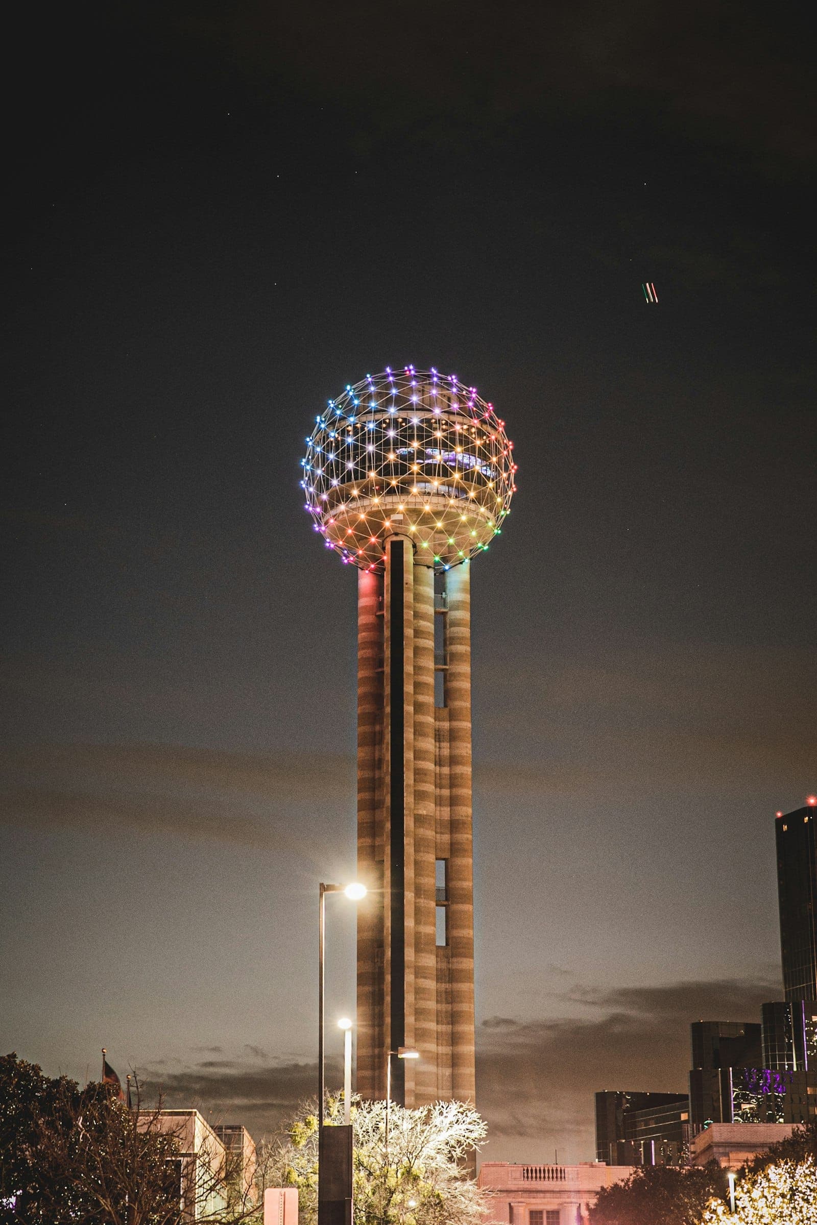 Reunion Tower glowing over Dallas at night